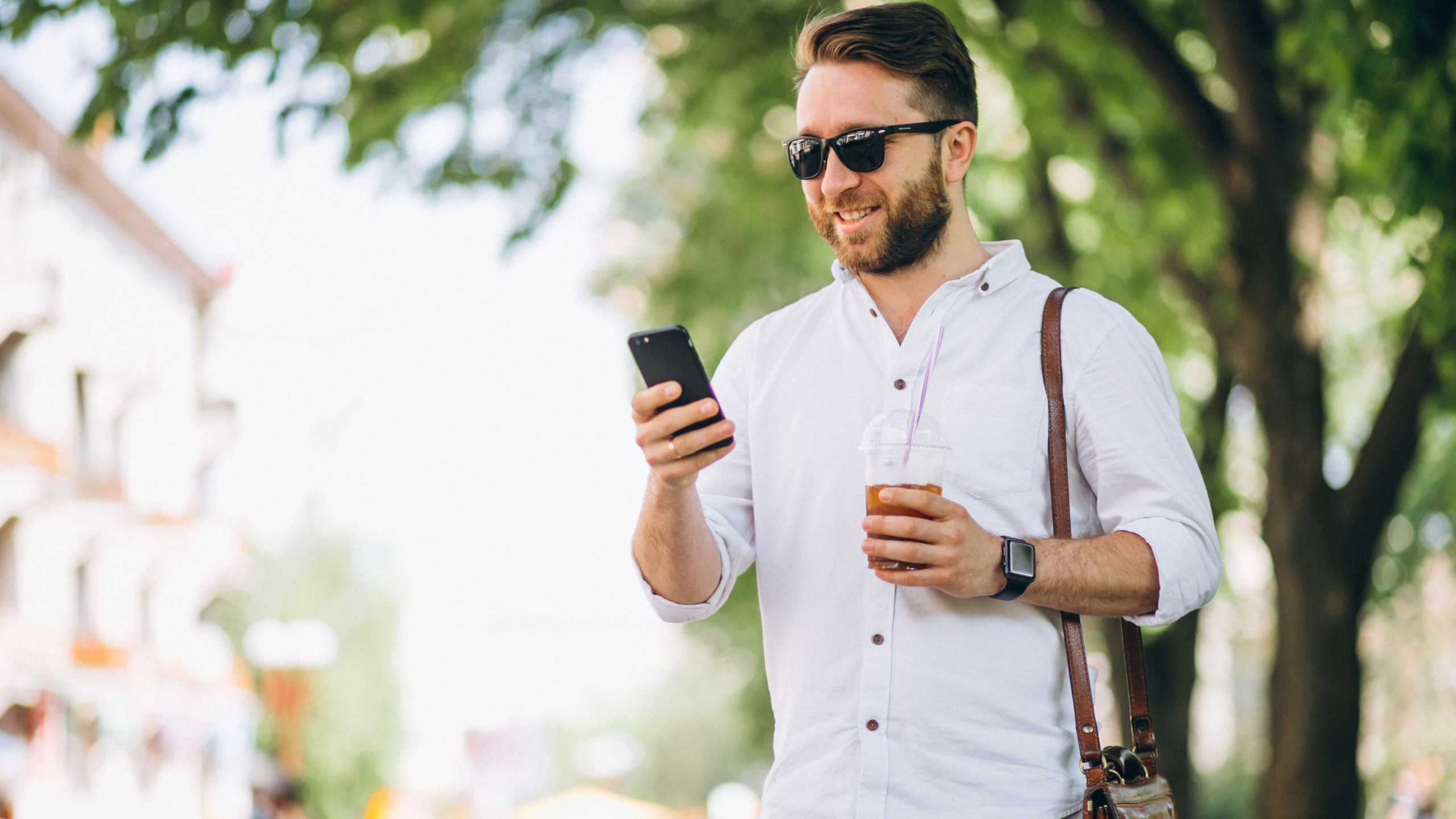 Homem de óculos de sol segura o celular para consultar uma IA para saúde mental.